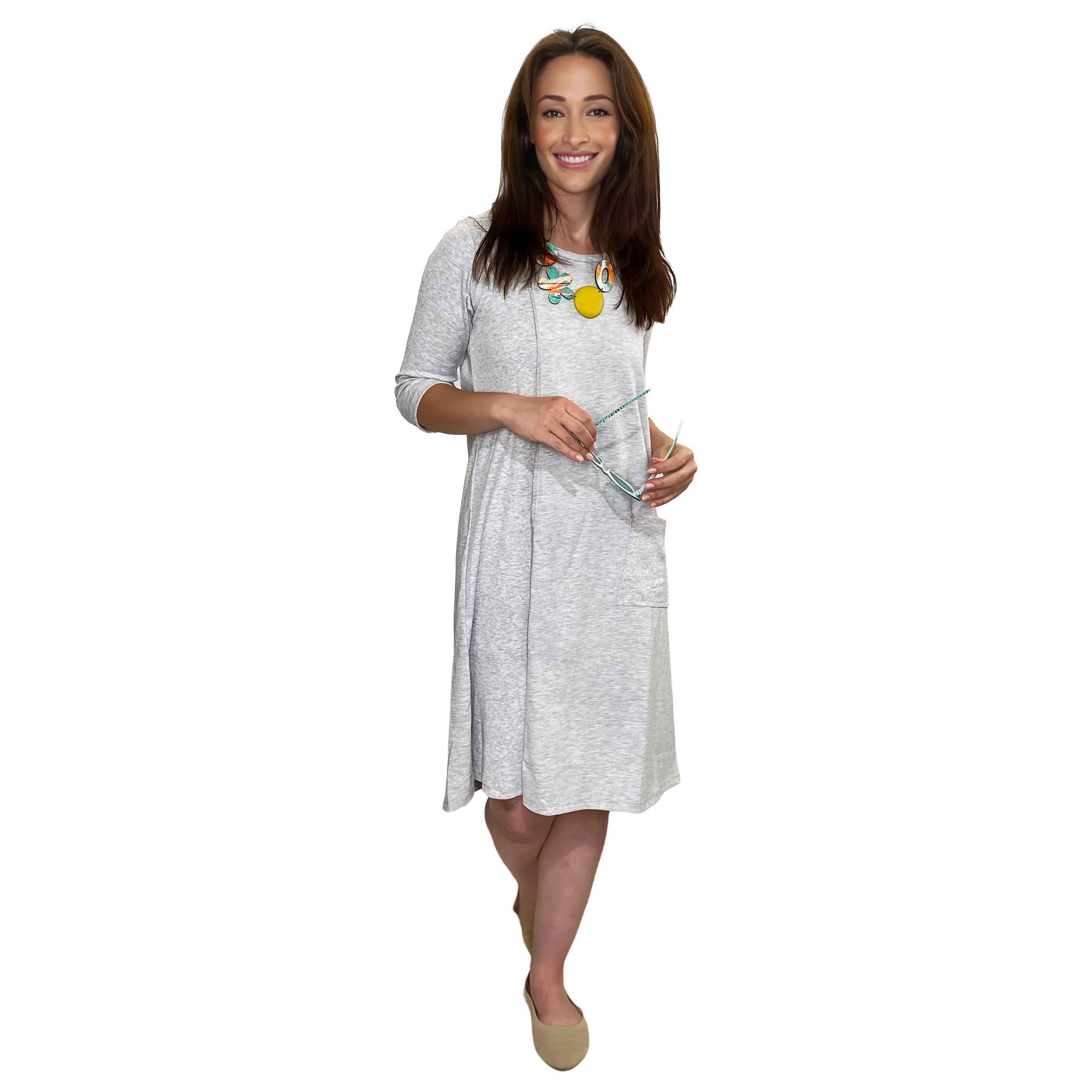 Woman wearing a gray nightgown holding a glass of water on a white background