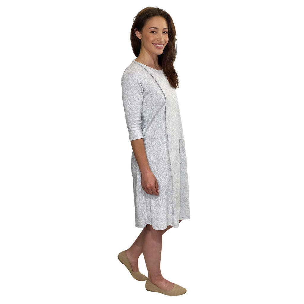 Woman wearing a light gray dress on a white background