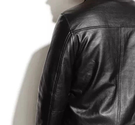 Close-up of a black leather jacket on a mannequin against a white background