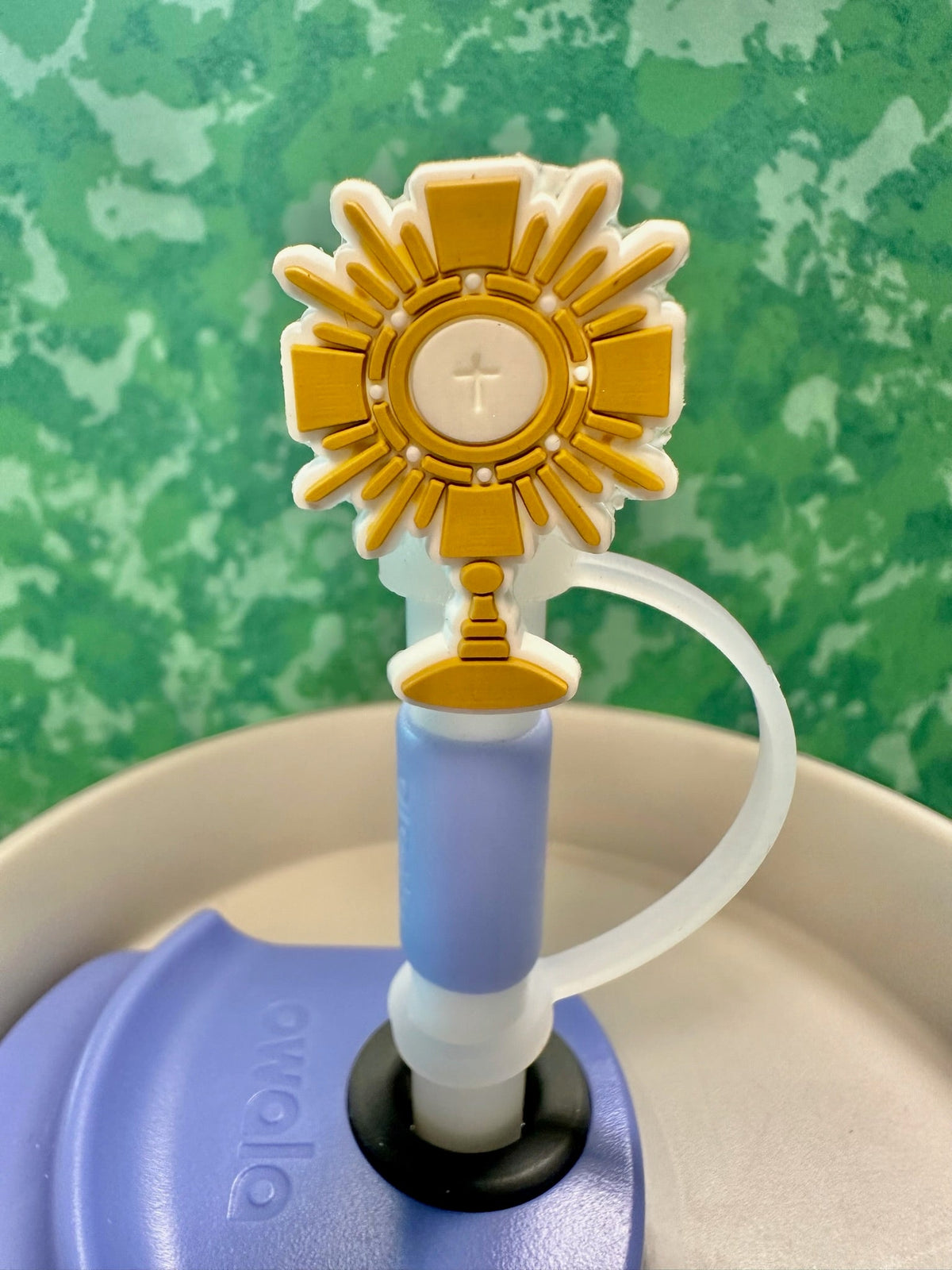Decorative water bottle cap with a sun-like design on a green background