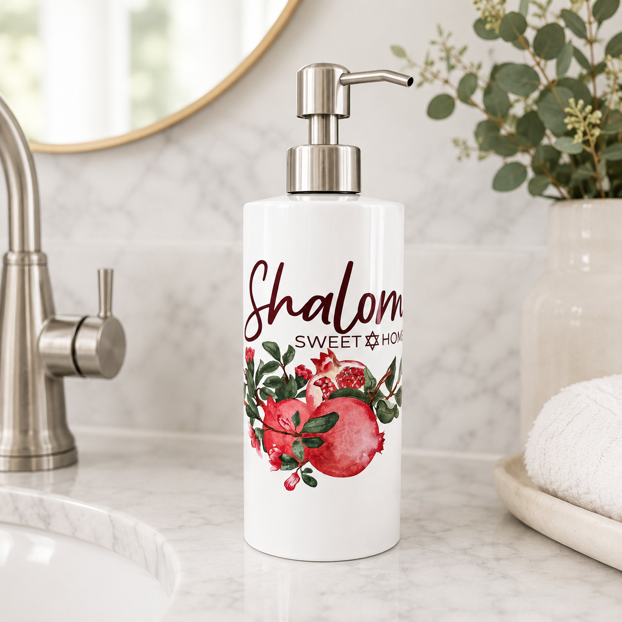 Soap dispenser with 'Shalom Sweet Home' text and pomegranate design on a bathroom counter.