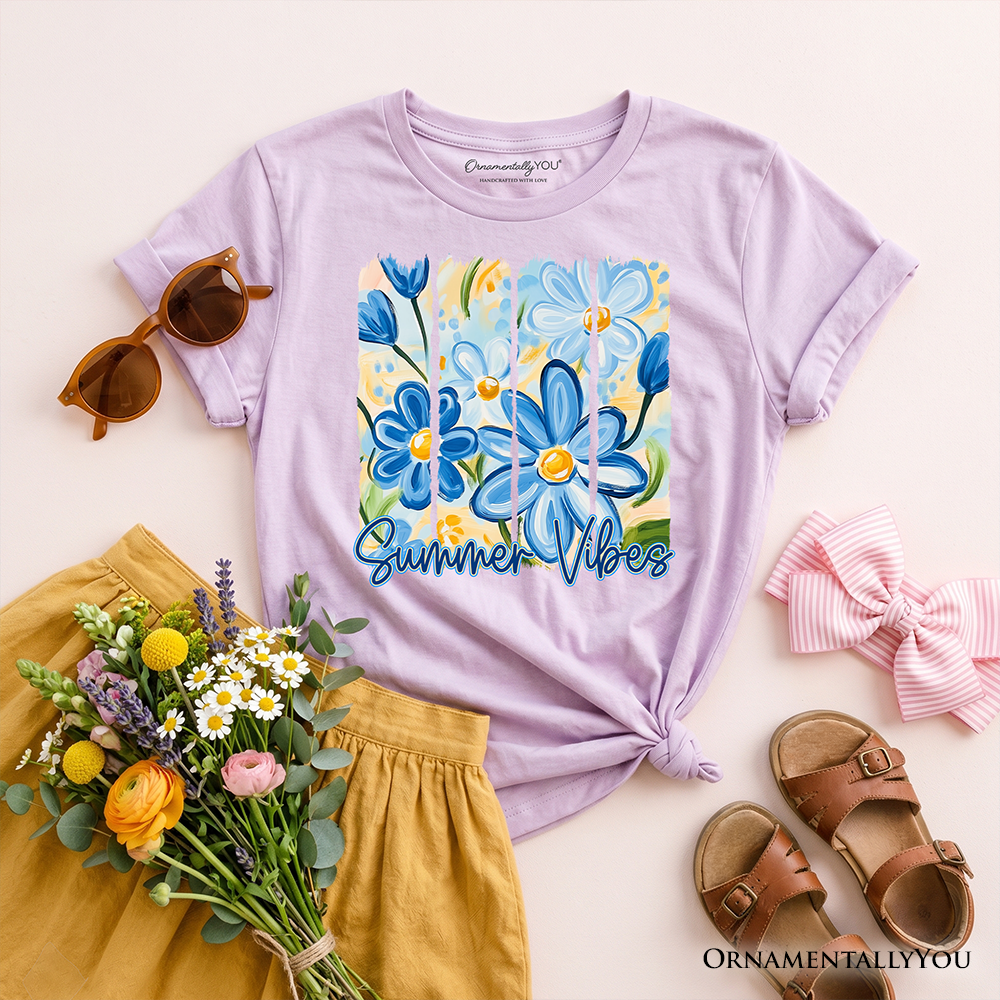 Lavender t-shirt with floral design and 'Summer Vibes' text, surrounded by sunglasses, sandals, and flowers on a light background.