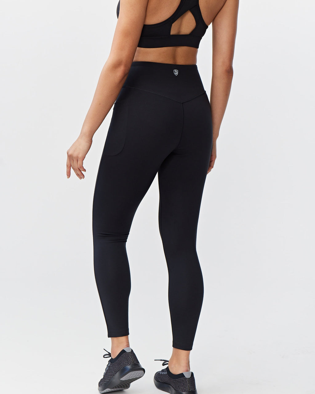 Person wearing black athletic leggings on a white background