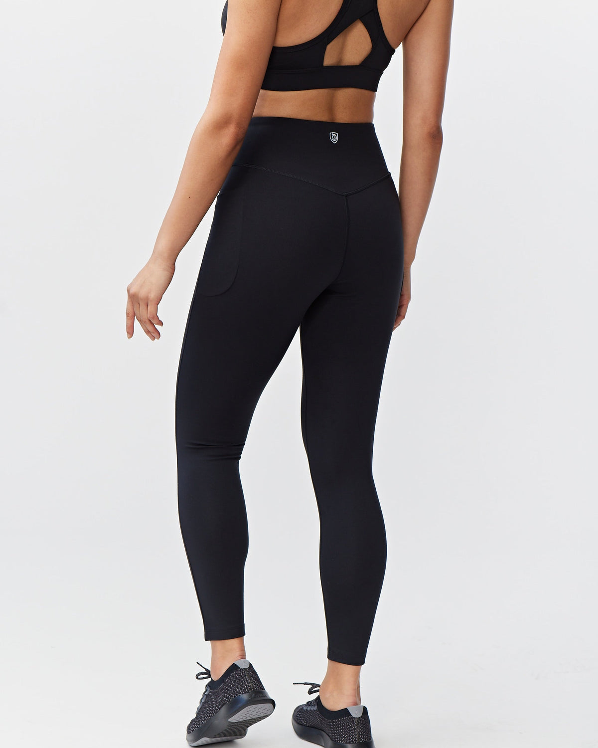 Person wearing black athletic leggings on a white background
