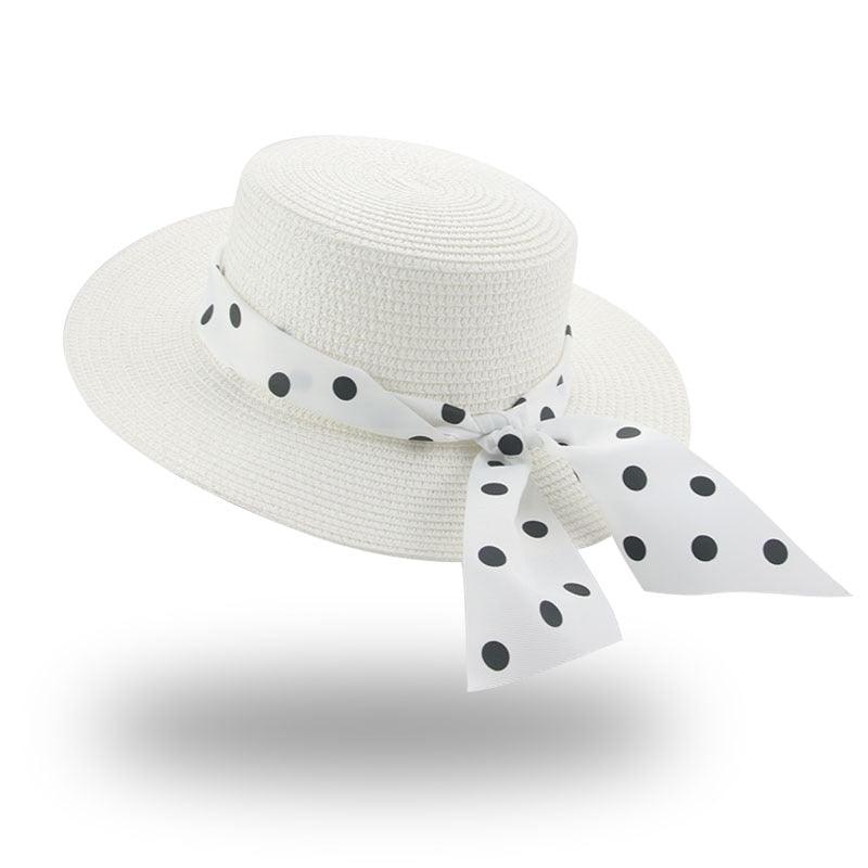 White straw hat with a polka dot ribbon on a white background