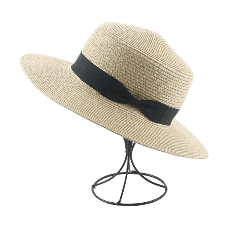Beige straw hat with a black band on a white background