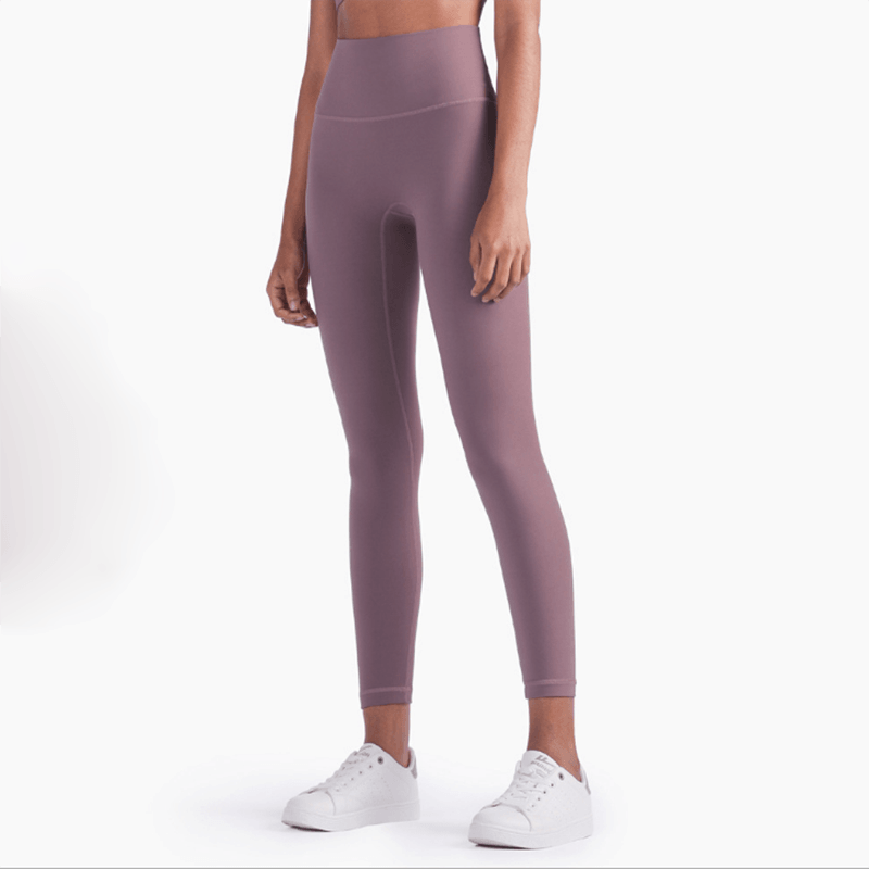 Person wearing mauve leggings on a white background