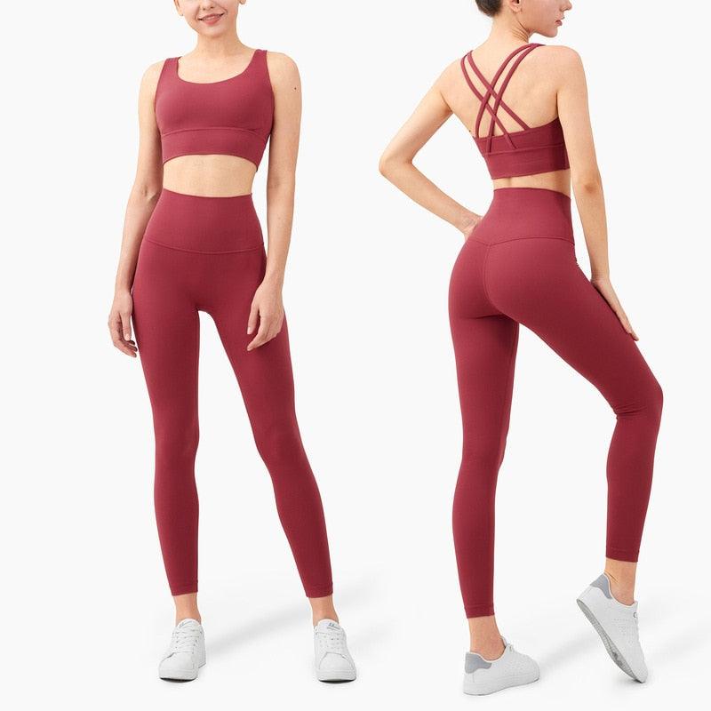 Maroon athletic outfit with sports bra and leggings on a white background