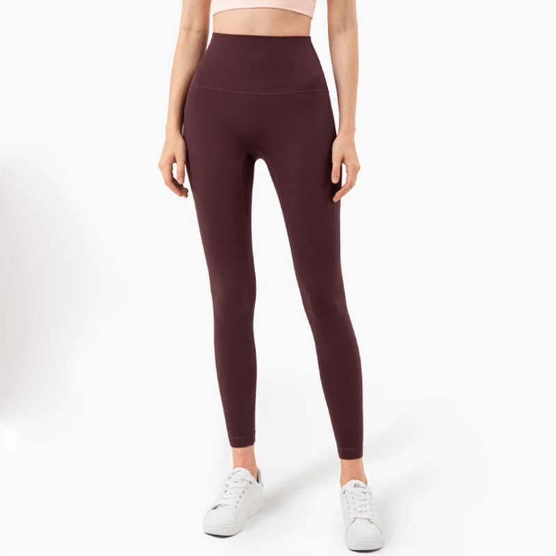 Maroon leggings worn by a person on a white background