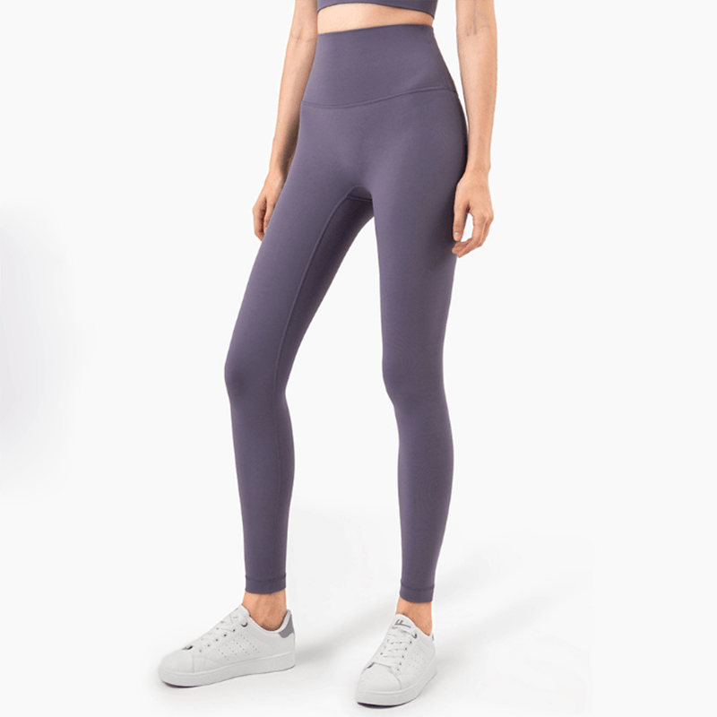 Person wearing purple leggings and white sneakers on a white background