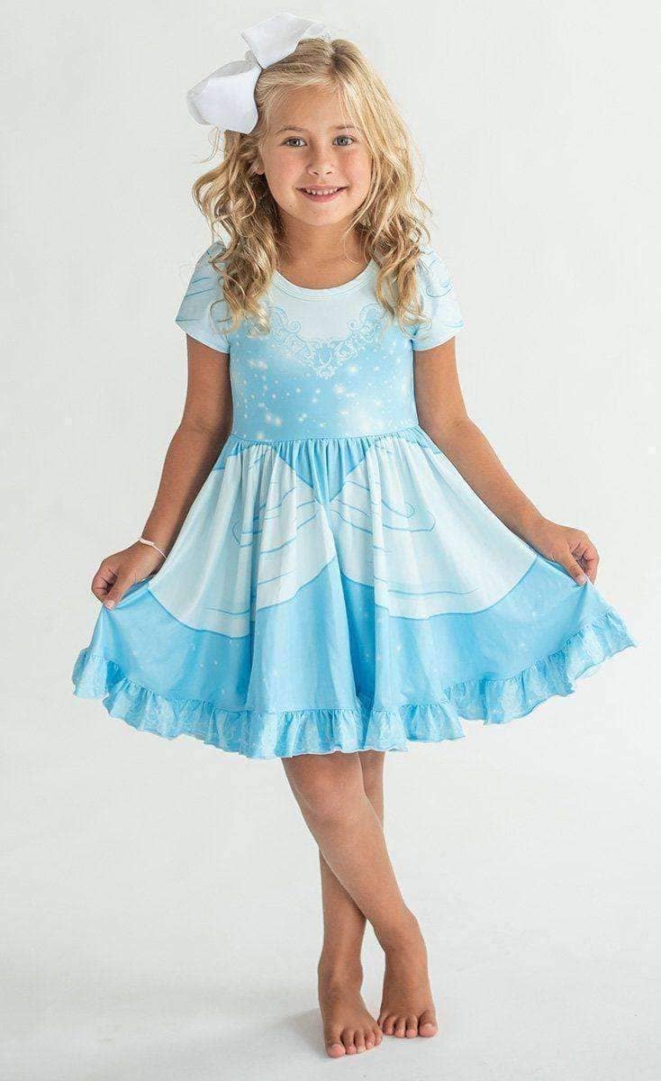 Young girl wearing a blue and white dress with a white bow on a light gray background
