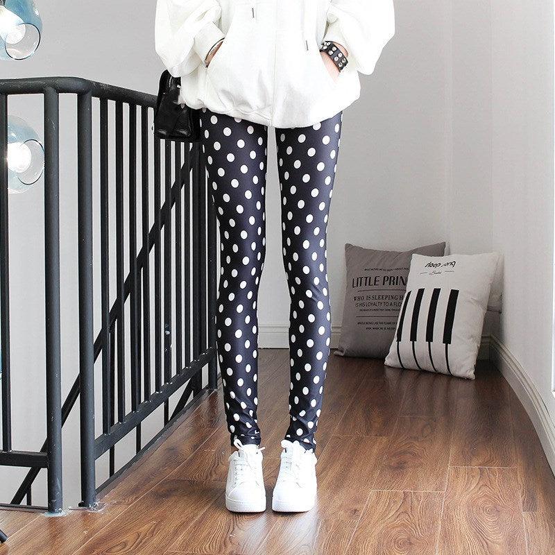 Person wearing black polka dot leggings and white sneakers in a room with a staircase and pillows.