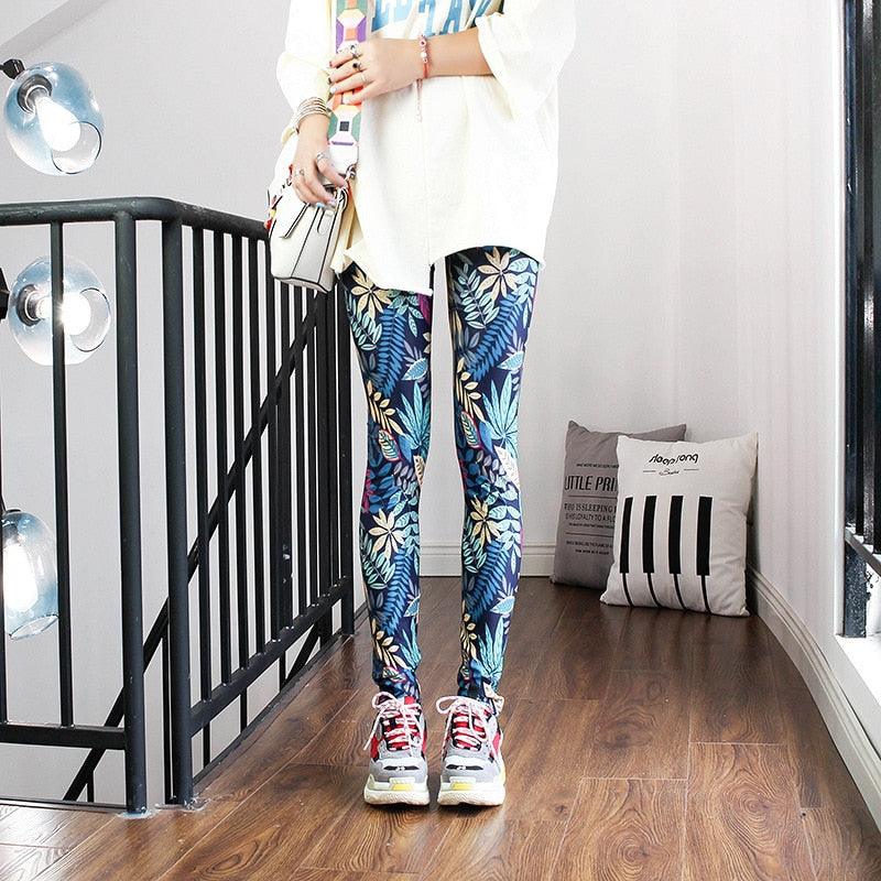 Person wearing colorful floral leggings in a room with pillows on the floor.