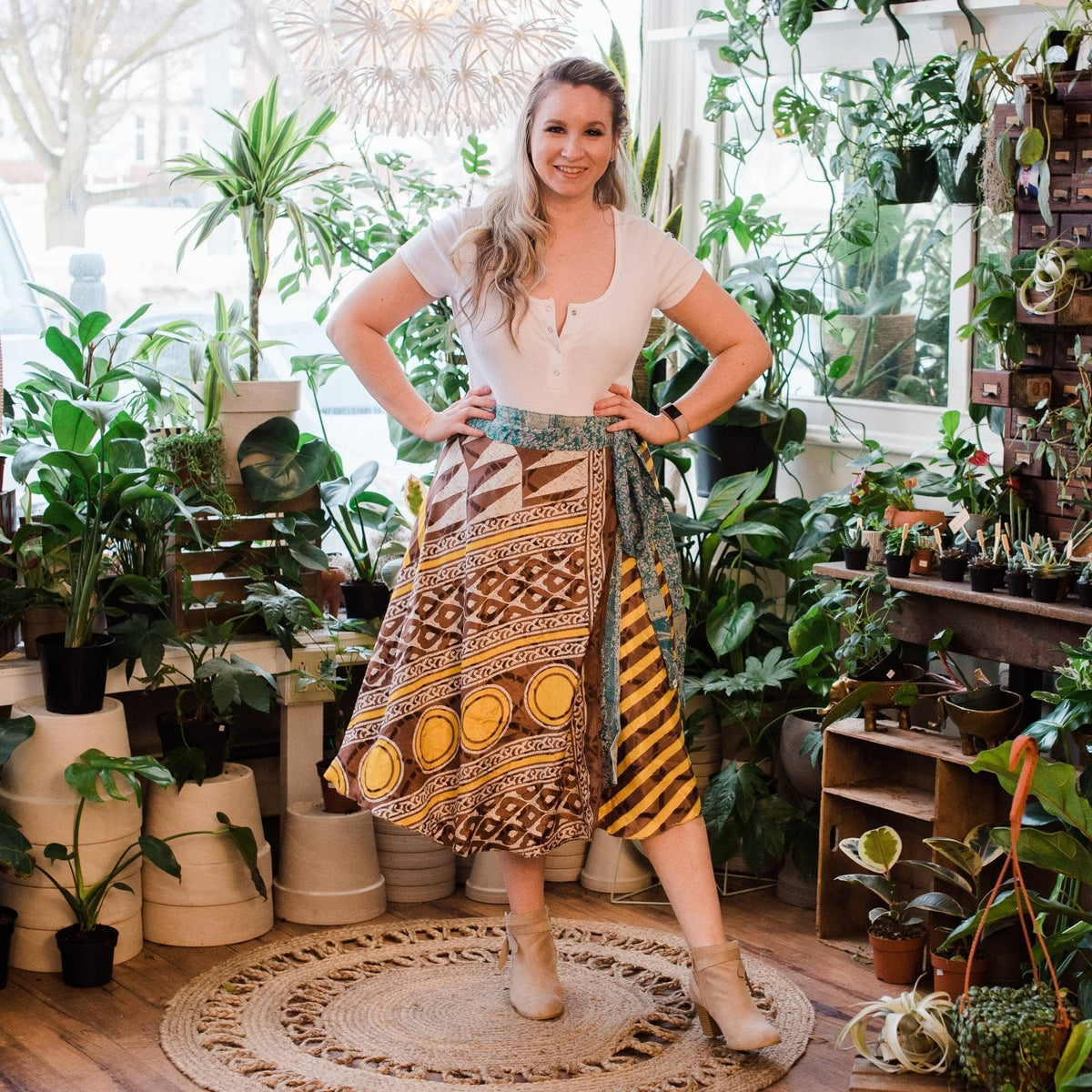 Woman standing in a plant store surrounded by various potted plants